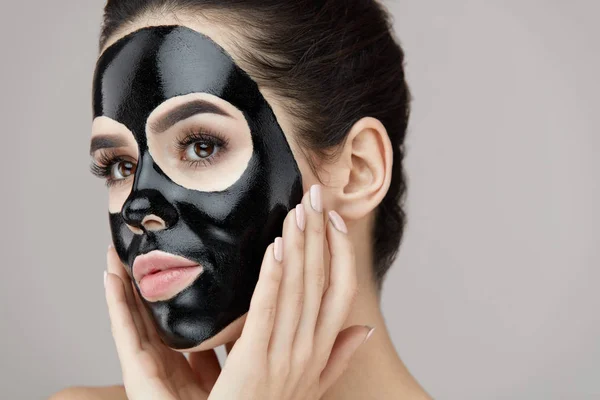 Mulher Beauty Face Care. Menina aplicando máscara de descascamento preto na pele — Fotografia de Stock