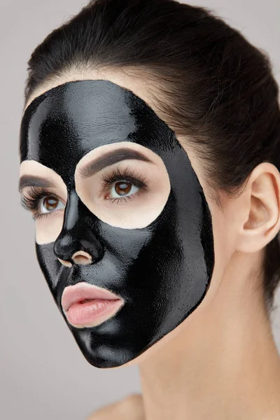 Gezicht schoonheidsverzorging. Portret meisje met zwarte schil masker op huid — Stockfoto