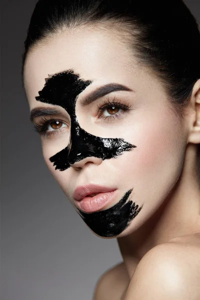 Косметика краси. Жінка з чорною маскою для догляду за шкірою на обличчі . — стокове фото