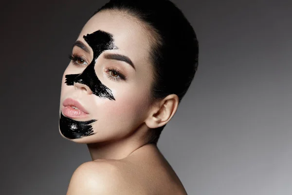 Schönheitskosmetik. Weibchen mit schwarzer Hautpflege-Peelingmaske im Gesicht. — Stockfoto