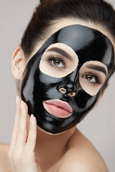 Belleza cuidado de la piel producto. Retrato de mujer con máscara de pelado negro —  Fotos de Stock