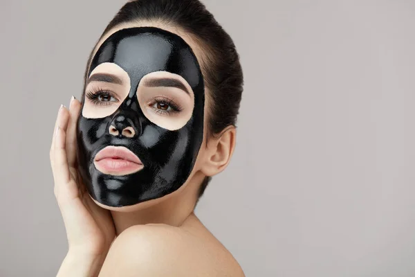 Fêmea beleza rosto tratamento da pele. Menina com preto peeling máscara — Fotografia de Stock