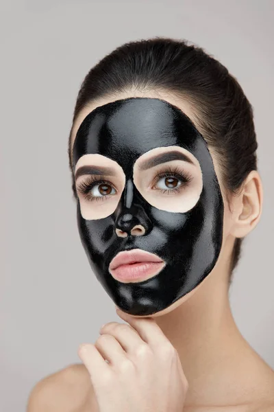 Cuidado facial de belleza. Primer plano femenino con máscara de pelado negro en la piel —  Fotos de Stock