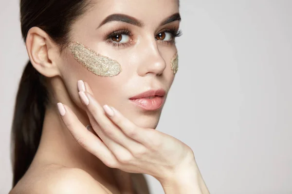 Frau Gesichtspflege. schönes Mädchen mit kosmetischer Peelingmaske — Stockfoto