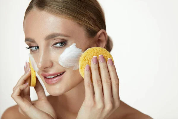 Gesichtspflege. Schönes Mädchen putzt Gesicht mit Seife und Schwamm — Stockfoto