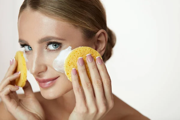 Ansikte hudvård. Vacker flicka rengöring ansikte med tvål och svamp — Stockfoto