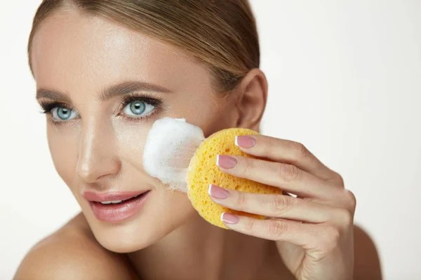 Cura del viso di bellezza. Sorridente donna pulizia viso con lavaggio facciale — Foto Stock