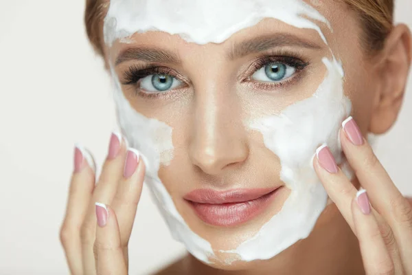 Lavarse la cara. Mujer aplicando producto cosmético en la cara de belleza —  Fotos de Stock