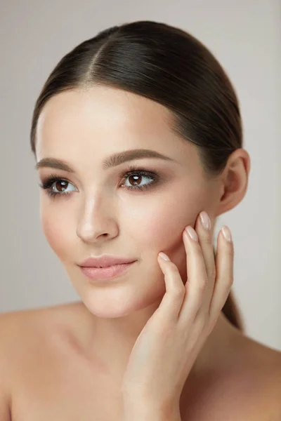 Cuidado de rosto cosmético. Mulher jovem acariciando a pele facial — Fotografia de Stock