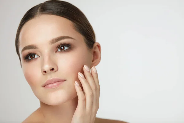 Frau Schönheit Gesicht. Weibchen mit natürlichem Make-up berühren Gesichtshaut — Stockfoto