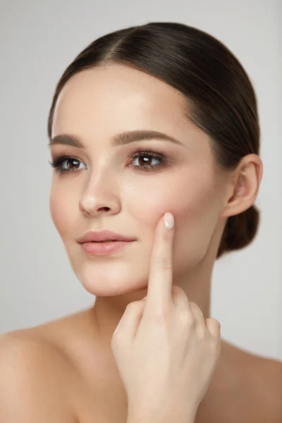 De schoonheid van de huid van de vrouw. Meisje met natuurlijke make-up aanraken van de huid — Stockfoto