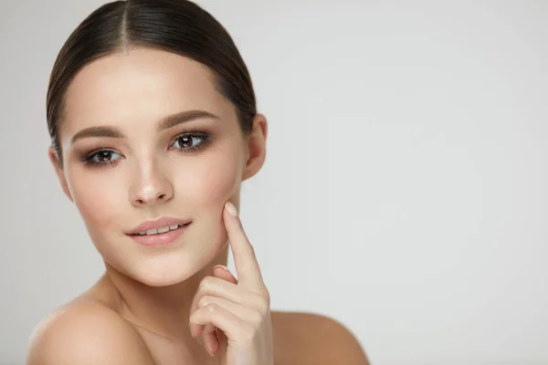 De schoonheid van de huid van de vrouw. Meisje met natuurlijke make-up aanraken van de huid — Stockfoto