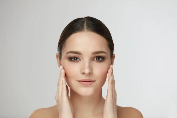 Schönheit Frauengesicht. Mädchen mit natürlichem Make-up berühren Gesichtshaut — Stockfoto