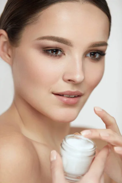 Gesichtspflege. Frau mit natürlichem Make-up hält Creme — Stockfoto