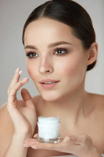 Cosméticos de belleza de mujer. Hermosa crema de aplicación femenina en la cara — Foto de Stock