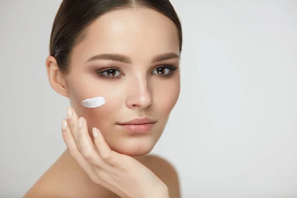 Hermosa cara de mujer con crema en piel suave fresca. Cosméticos —  Fotos de Stock