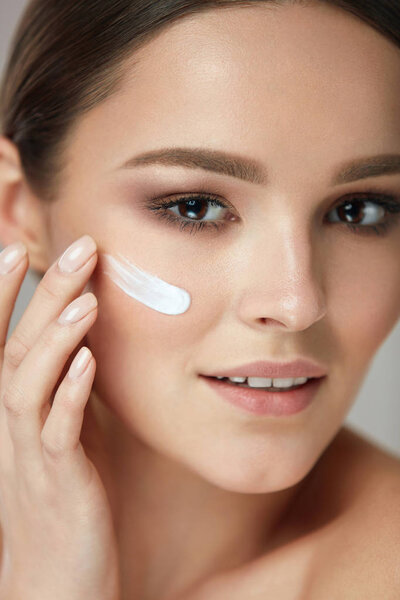 Facial Care. Closup Beautiful Woman Putting Skin Cream On Face