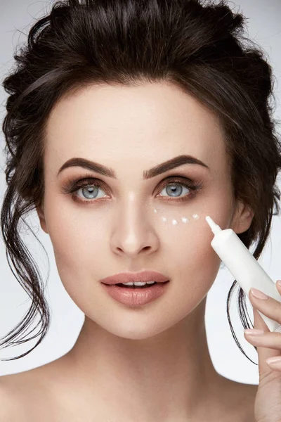 Cuidado de la piel ocular. Mujer aplicando crema para los ojos en la piel — Foto de Stock