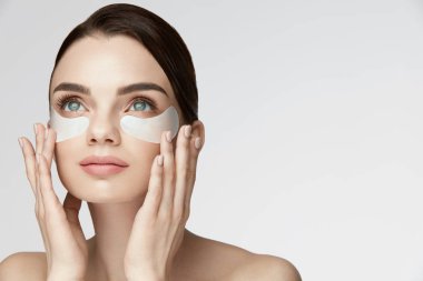 Güzellik yüz cilt bakımı. Yüzünde altında göz düzeltme eklerini uygulamayı kadın