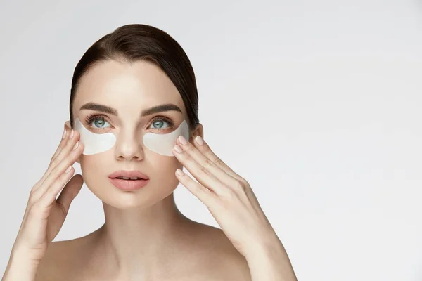 Beauté visage Soins de la peau. Femme appliquant des patchs sous les yeux sur le visage — Photo