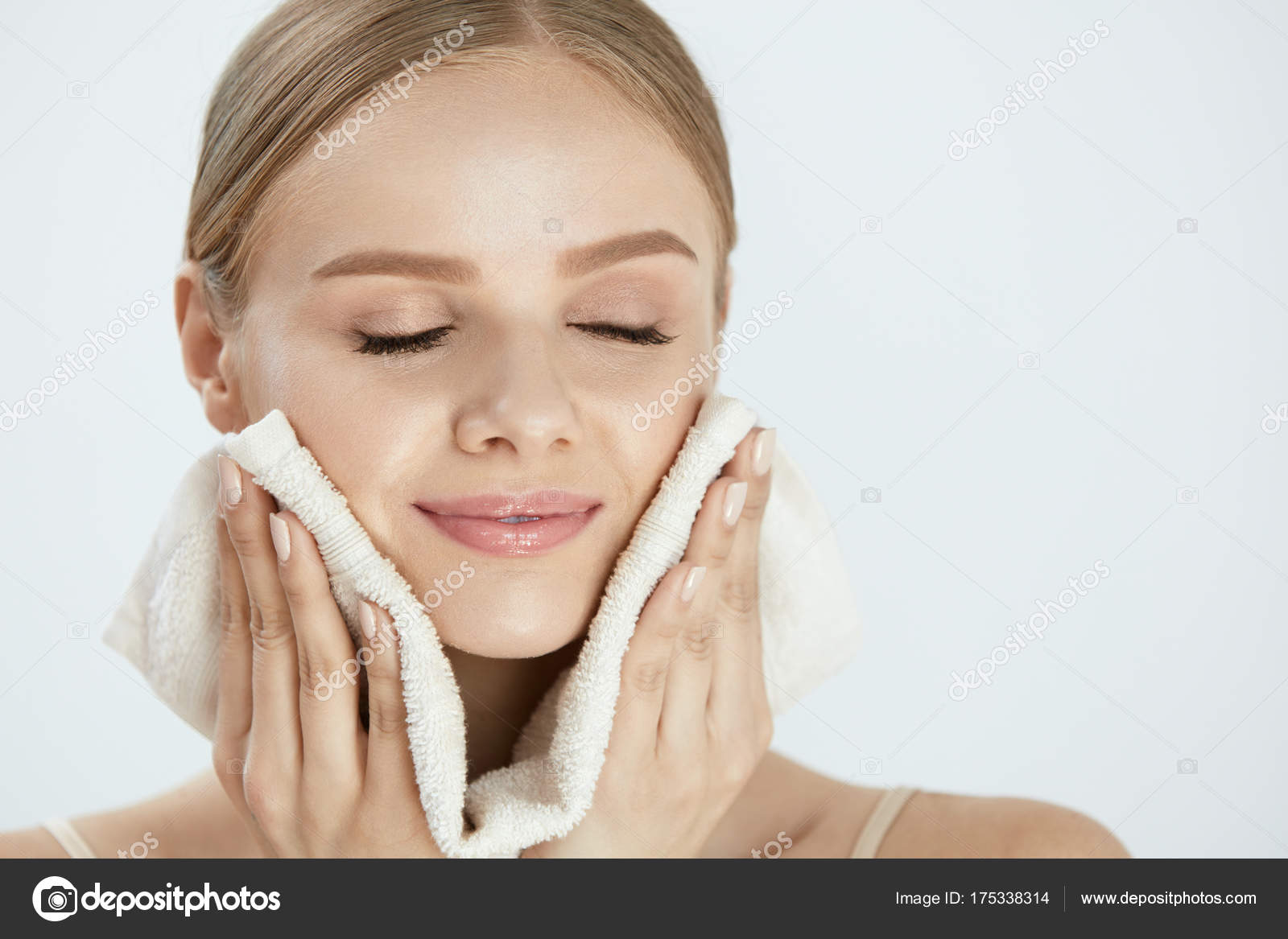 Mujer limpieza de la piel de la cara con toalla blanca: fotografía