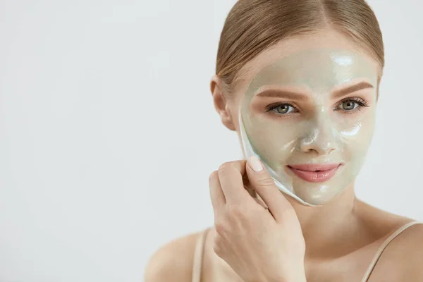 Ansiktsmask. Närbild vacker flicka att ta bort masken från huden — Stockfoto
