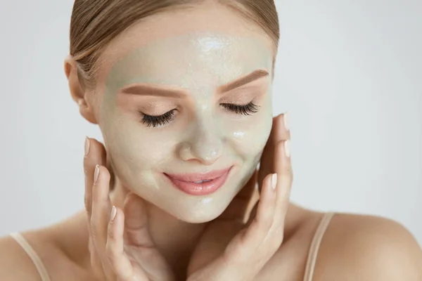 Máscara Cosmética. Mulher sorridente bonita aplicando máscara no rosto — Fotografia de Stock