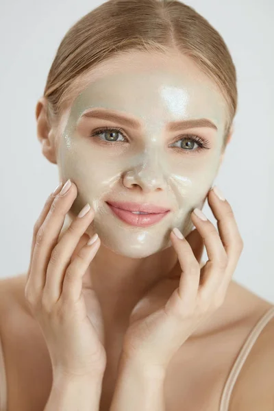 Kosmetycznych maski. Piękna kobieta uśmiechający się zastosowanie maski na twarz — Zdjęcie stockowe