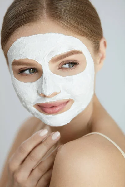 Mascarilla para el cuidado de la piel. Primer plano de la mujer con la máscara de la cara blanca —  Fotos de Stock