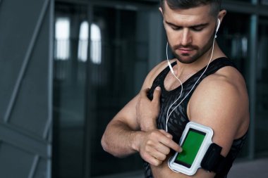 Sport and Music. Man Listening Music On Phone clipart