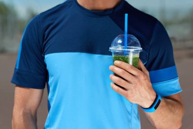 Diyet içeceği. Yeşil Smoothie elinde tutan adam.