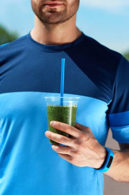 Diyet içeceği. Yeşil Smoothie elinde tutan adam.