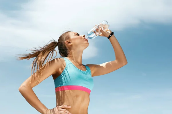 Frau trinkt Wasser nach dem Laufen. — Stockfoto