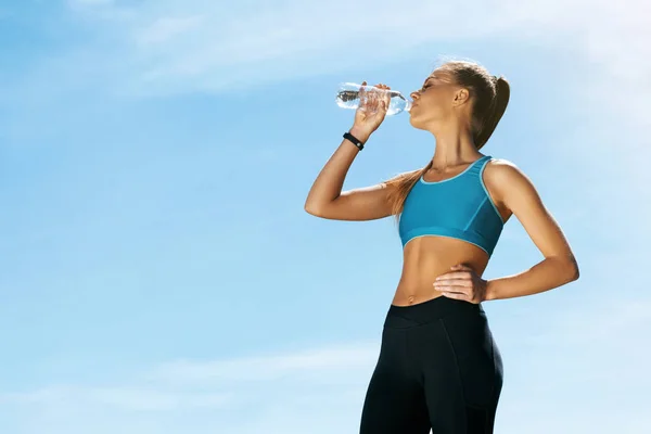 Жінка п'є воду після бігу . — стокове фото