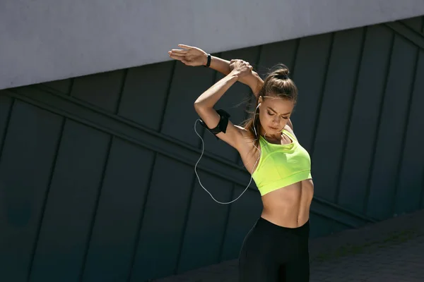 Frau streckt Körper, macht Übungen auf der Straße — Stockfoto