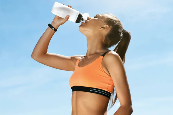 Frau trinkt Wasser nach dem Laufen. — Stockfoto
