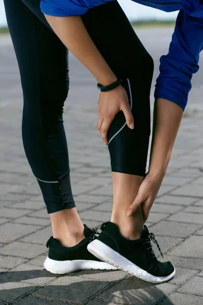 Lesión en la pierna. Mujer tocando la pierna dolorosa después de correr al aire libre —  Fotos de Stock