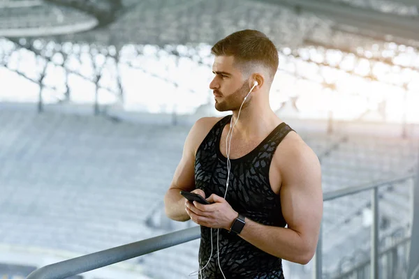 Mann hört beim Sport im Freien Musik am Telefon. — Stockfoto