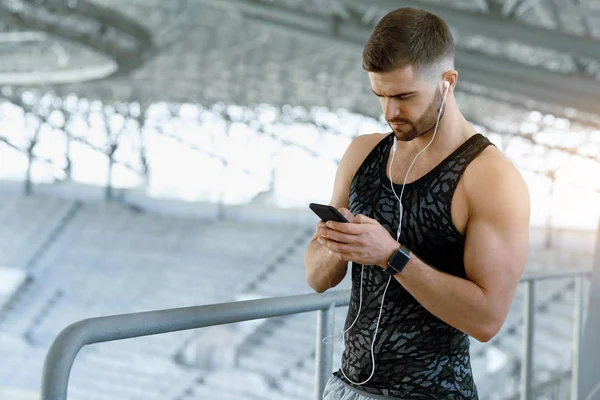 Mann hört beim Sport im Freien Musik am Telefon. — Stockfoto