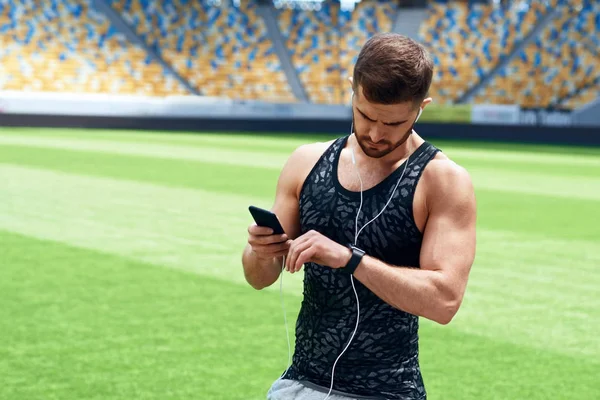 Mann hört Musik während er sich nach dem Laufen ausruht. — Stockfoto