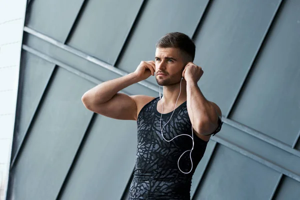 Mann hört Musik, macht Übungen auf der Straße. — Stockfoto