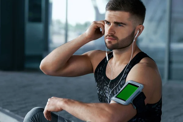 Sport und Musik. Mann hört Musik am Telefon — Stockfoto