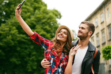 Güzel turistik çift alarak fotoğraf telefonu sokakta