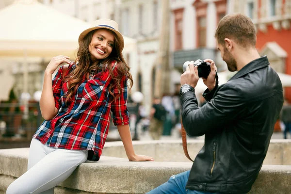 Pareja enamorada. Hombre tomando fotos de hermosa mujer en la calle . — Foto de Stock