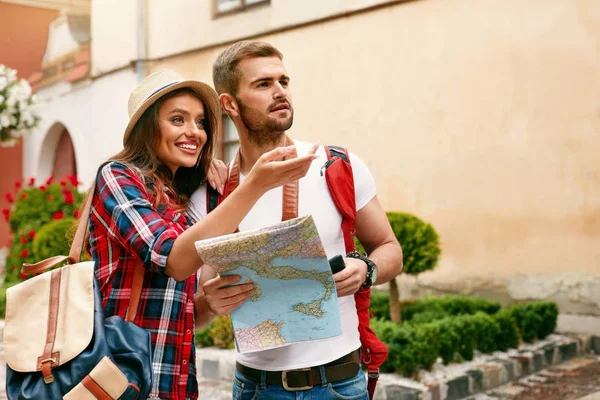 Couple Of Travelers Using Map For Sightseeing In Town.