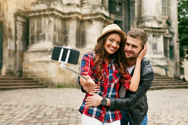 Preciosa pareja de turistas tomando fotos en el teléfono en la calle — Foto de Stock