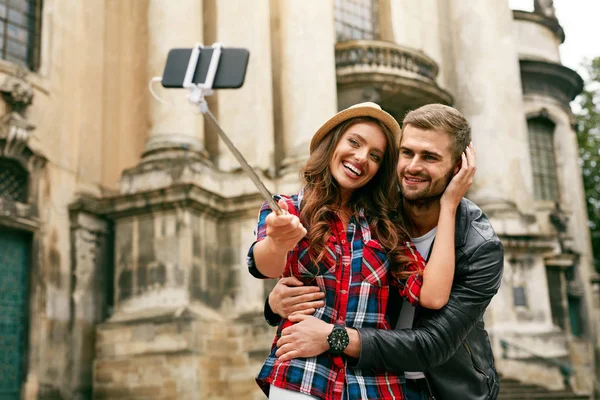 Όμορφη τουριστική ζευγάρι λήψη φωτογραφιών στο τηλέφωνό στον δρόμο — Φωτογραφία Αρχείου