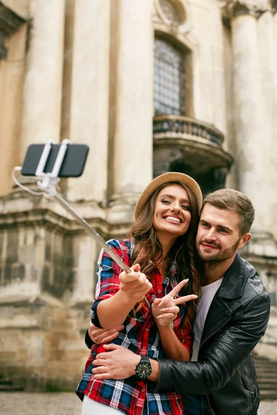 Preciosa pareja de turistas tomando fotos en el teléfono en la calle — Foto de Stock