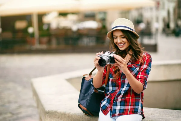 Schöne Touristenmädchen mit Kamera in den Händen. — Stockfoto