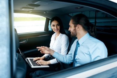 İş adamı ve arabanın içinde çalışan kadın.